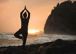 photo of a woman doing yoga near coast