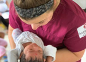 nursing student holds newborn