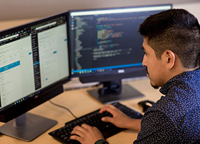A student employee writes code for a university website