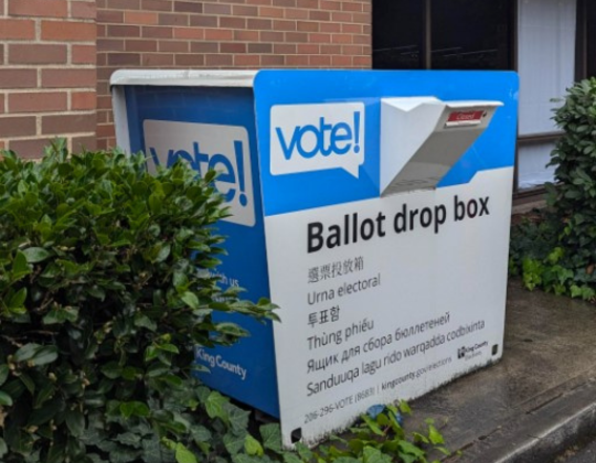 Ballot box near brick wall of SPU campus store.