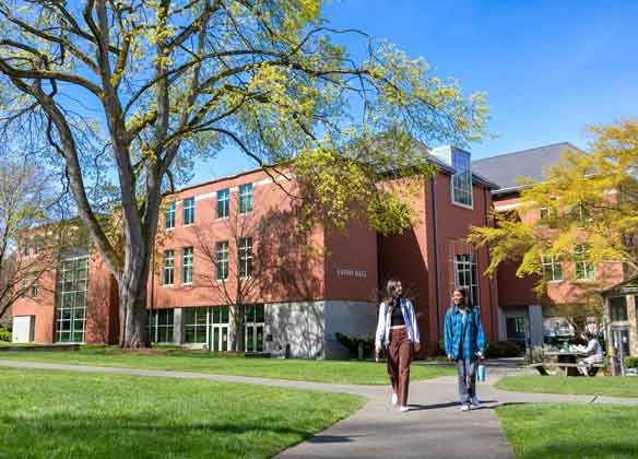 Wide shot of Eaton hall with two students walking in Tiffany Loop