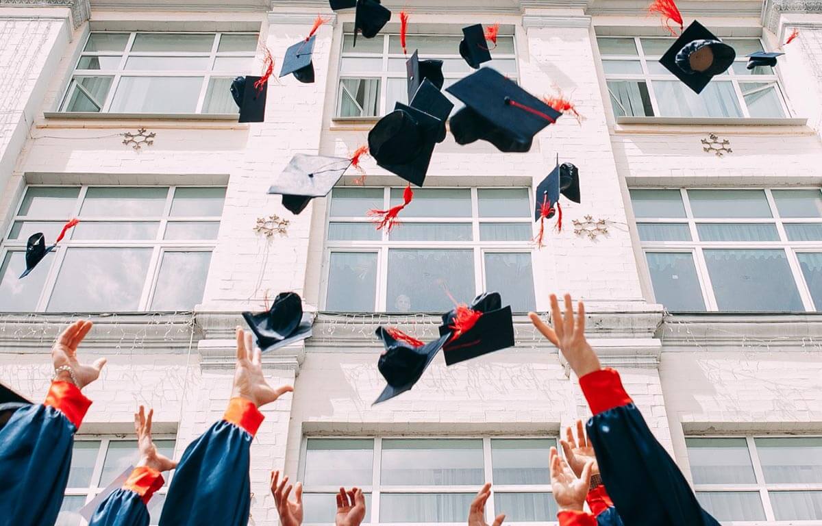 students throwing graduation caps in the air